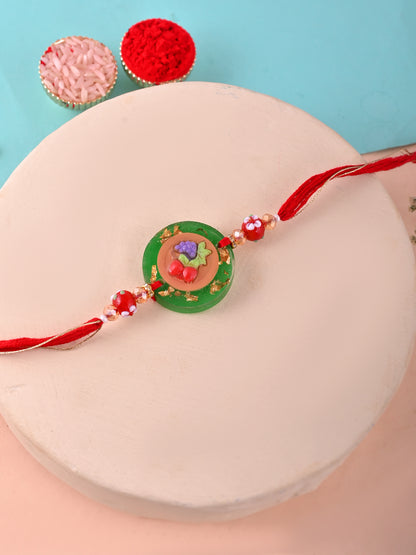 A Rakhi with a fruit plate design, likely symbolizing health or a festive theme.