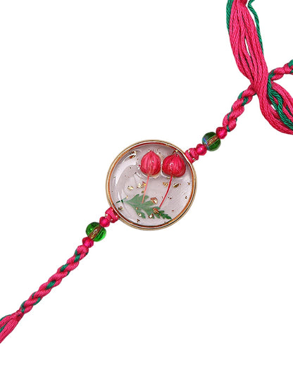 Preserved Botanical Rakhi With Dual Pink Buds And Handwoven Thread Work