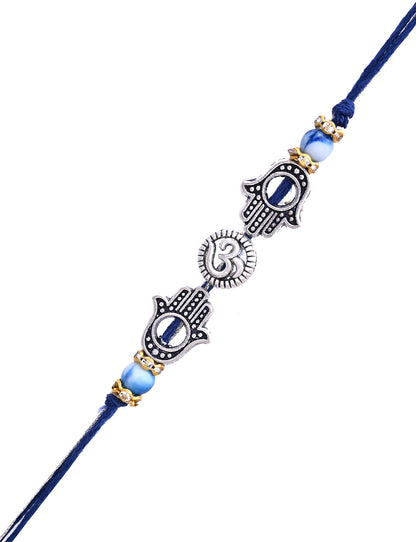 A Rakhi with double Hamsa hands and a central heart sun motif, with silver and blue accents.