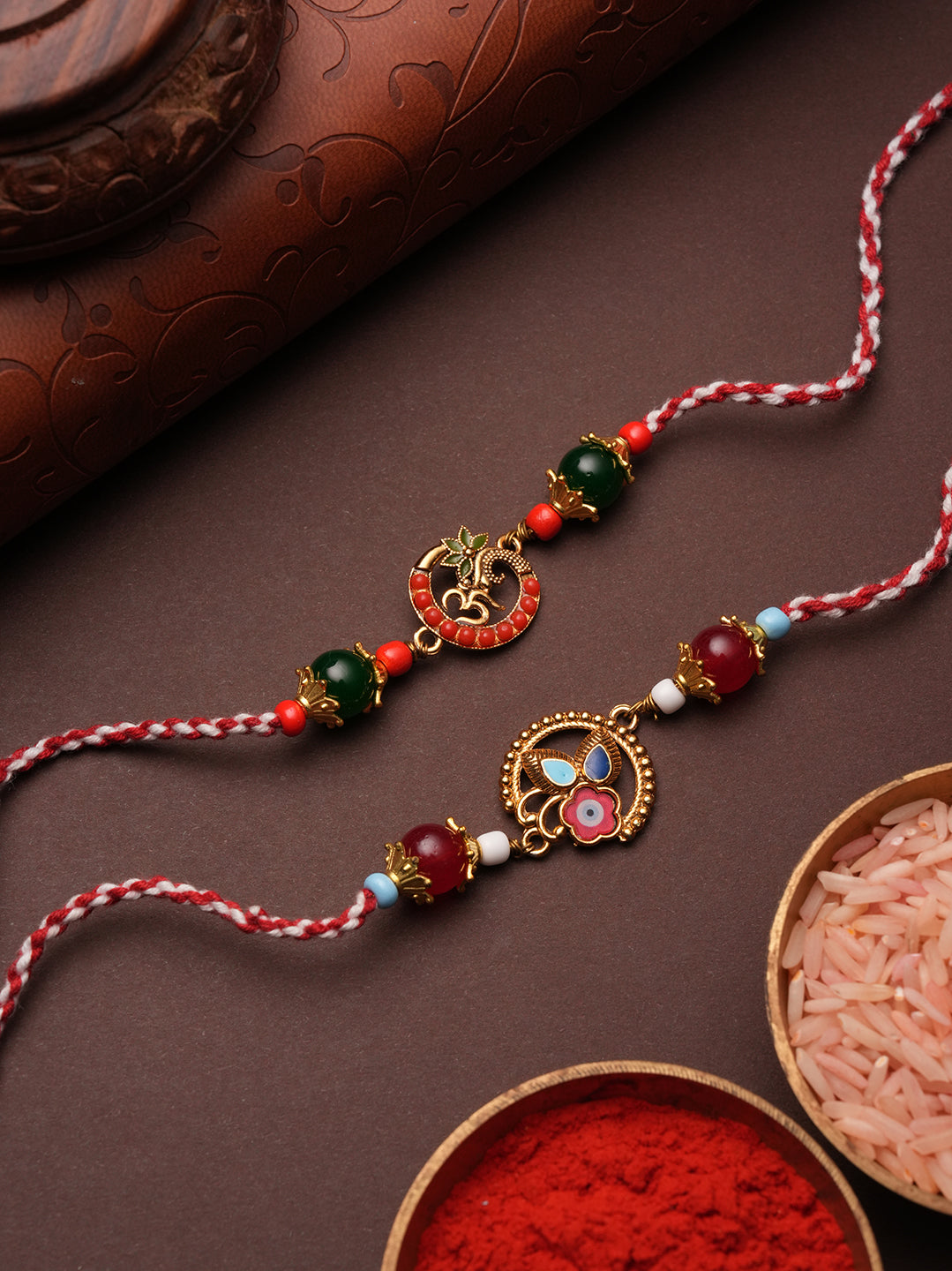 Intricate Floral Enamel Motif Rakhi Set with Ruby and Emerald Toned Accents