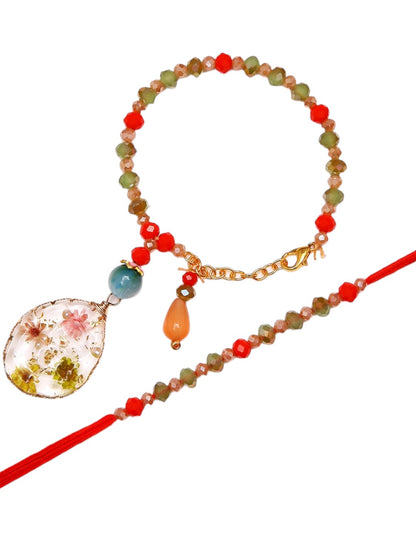 Handcrafted Rakhi Bracelet Set With Botanical Charm And Multicolor Stonework With Box